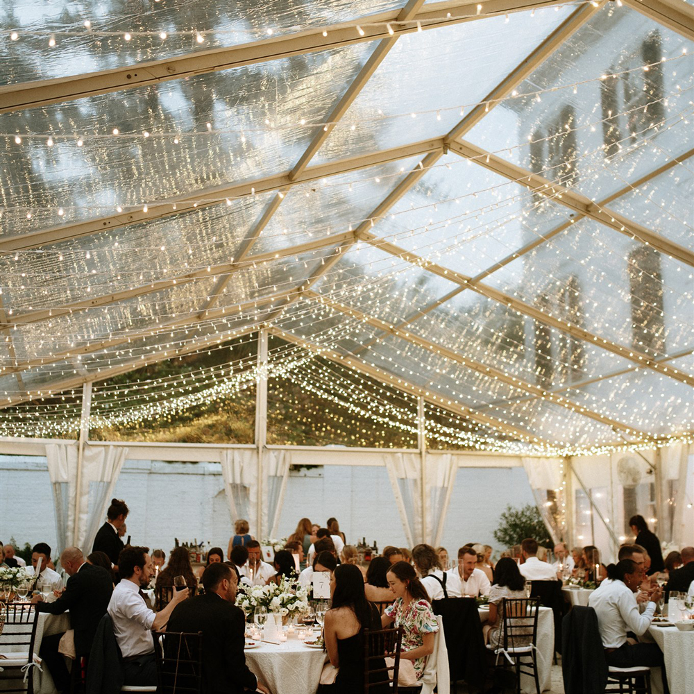 Clear top structure tent with lighting for an outdoor wedding hosted at The Mount in Lenox, Ma